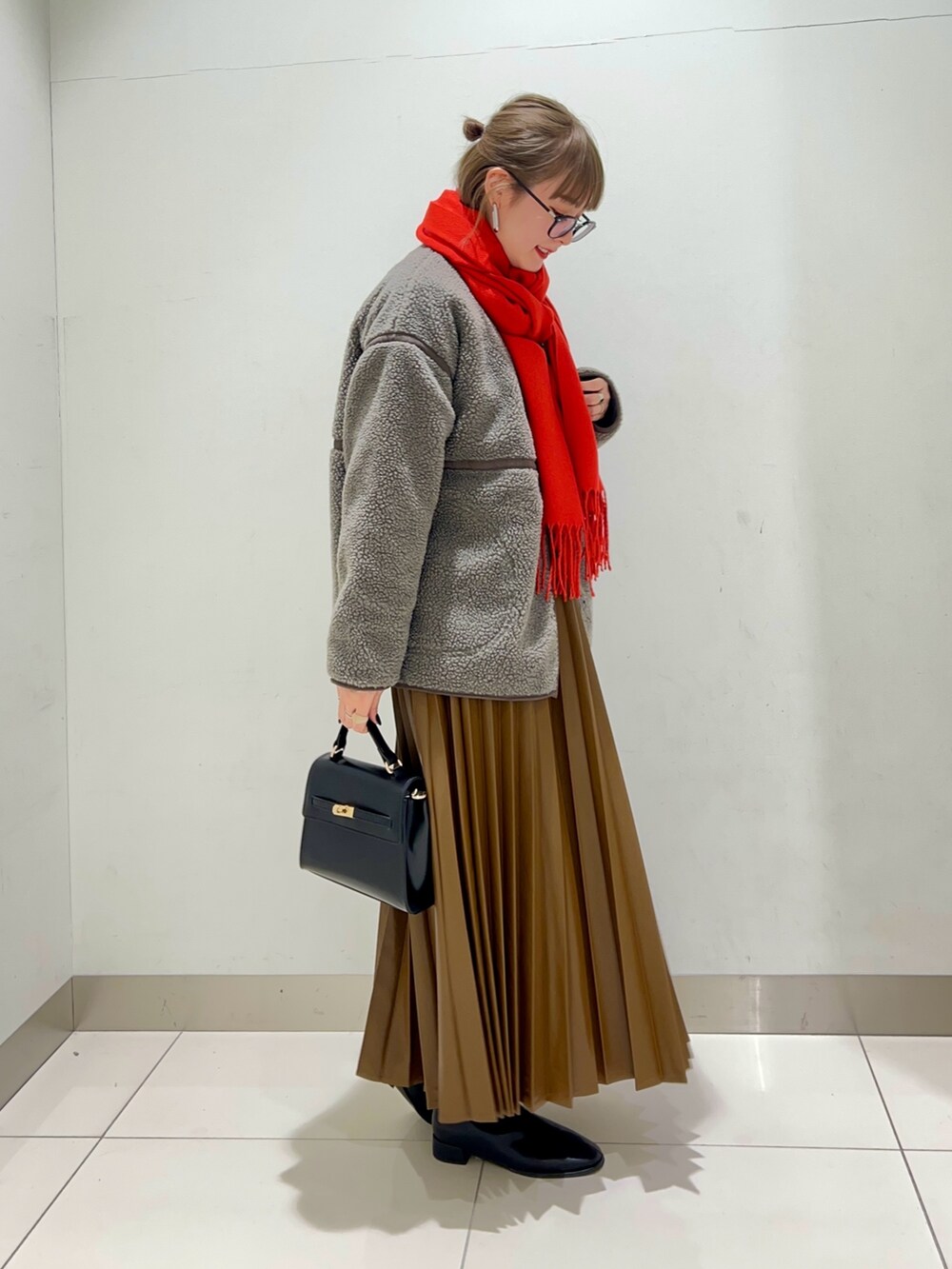 ブラック系のブーツ、ブラウン系のスカート、グレー系のその他アウターを着用したレディースの秋コーディネートの5枚目の写真