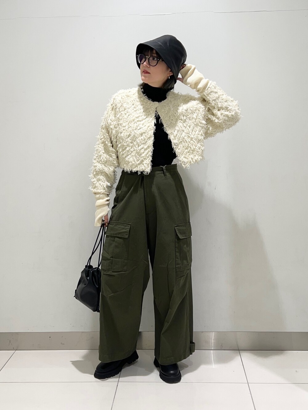 グリーン系のその他パンツ、ブラック系のショルダーバッグ、ブラック系のブーツを着用したレディースの秋コーディネートの6枚目の写真