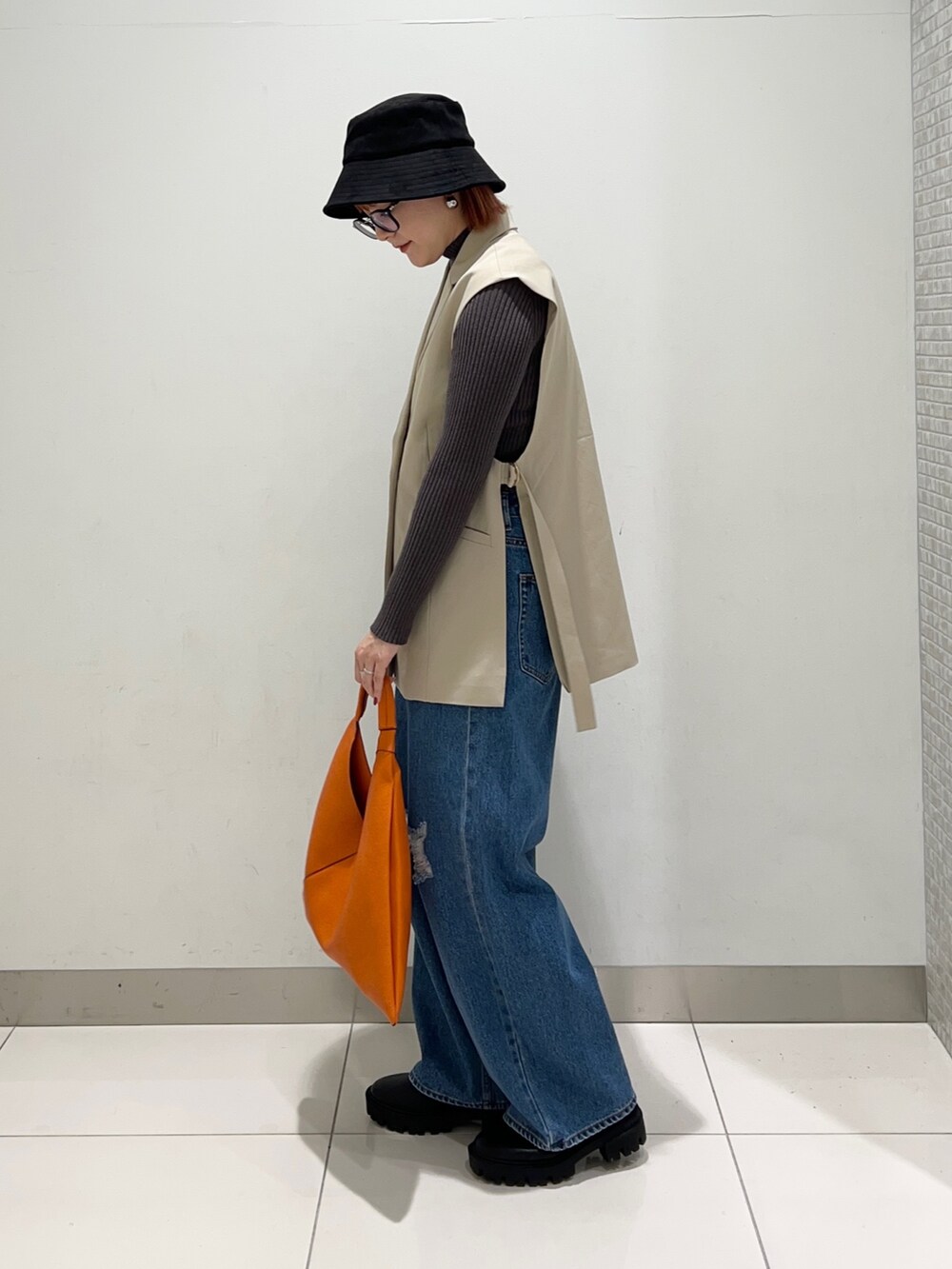 ベージュ系のジャケット/アウター、グレー系のニット/セーター、ブラック系のブーツを着用したレディースの秋コーディネートの3枚目の写真