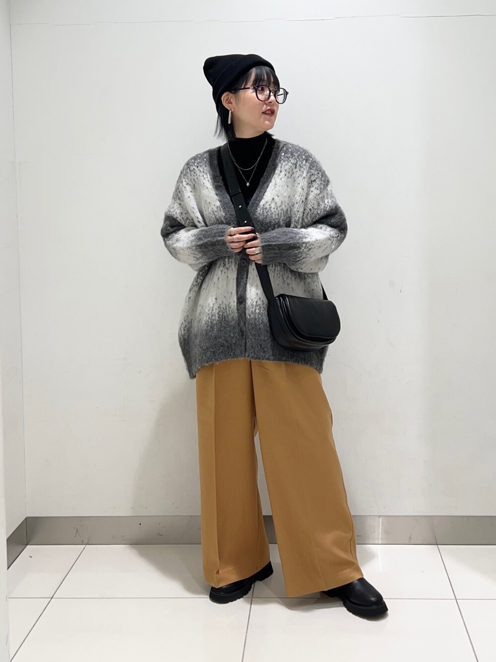 ブラック系のニット/セーター、ブラック系のショルダーバッグ、グレー系のカーディガン/ボレロを着用したレディースの秋コーディネートの6枚目の写真