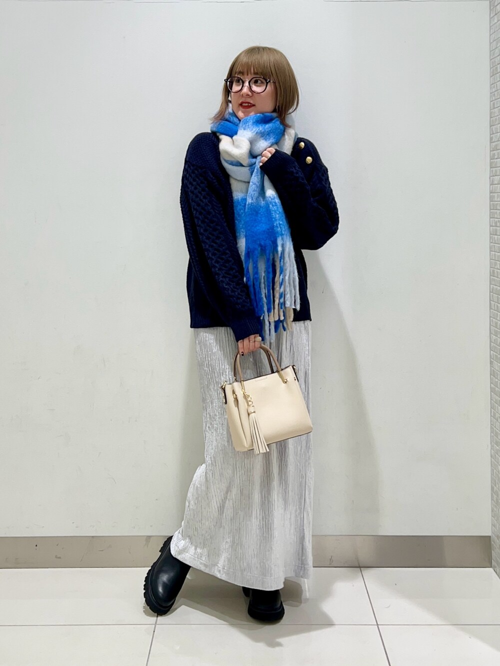 ブラック系のブーツ、グレー系のスカート、ブルー系のニット/セーターを着用したレディースの冬コーディネートの6枚目の写真