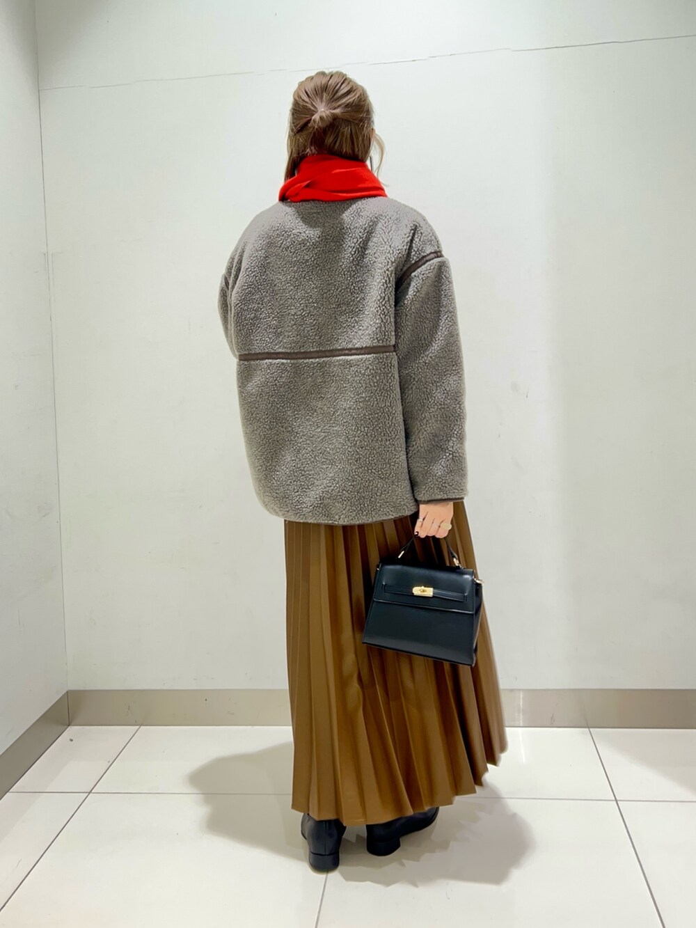 ブラック系のブーツ、ブラウン系のスカート、グレー系のその他アウターを着用したレディースの秋コーディネートの4枚目の写真