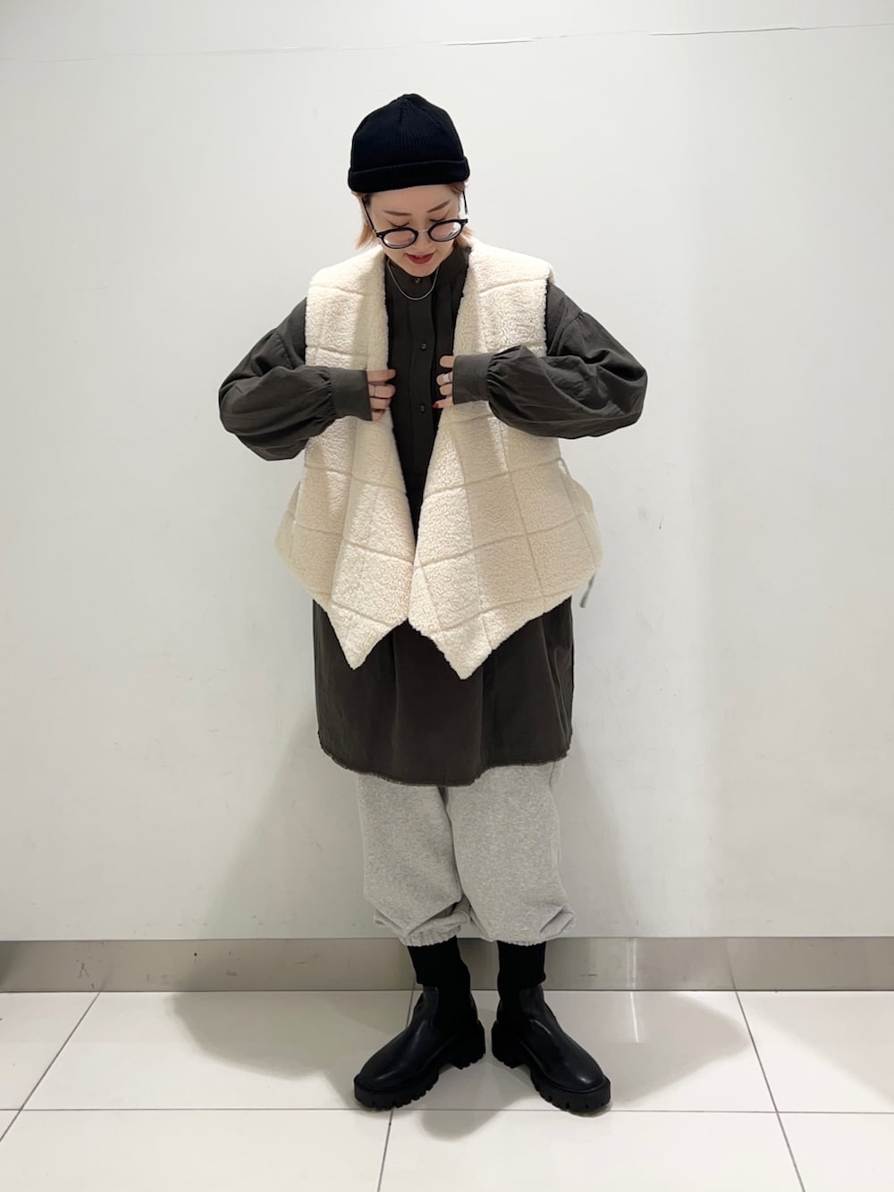 ホワイト系のベスト、グリーン系のワンピース、グレー系のその他パンツを着用したレディースの秋コーディネートの2枚目の写真