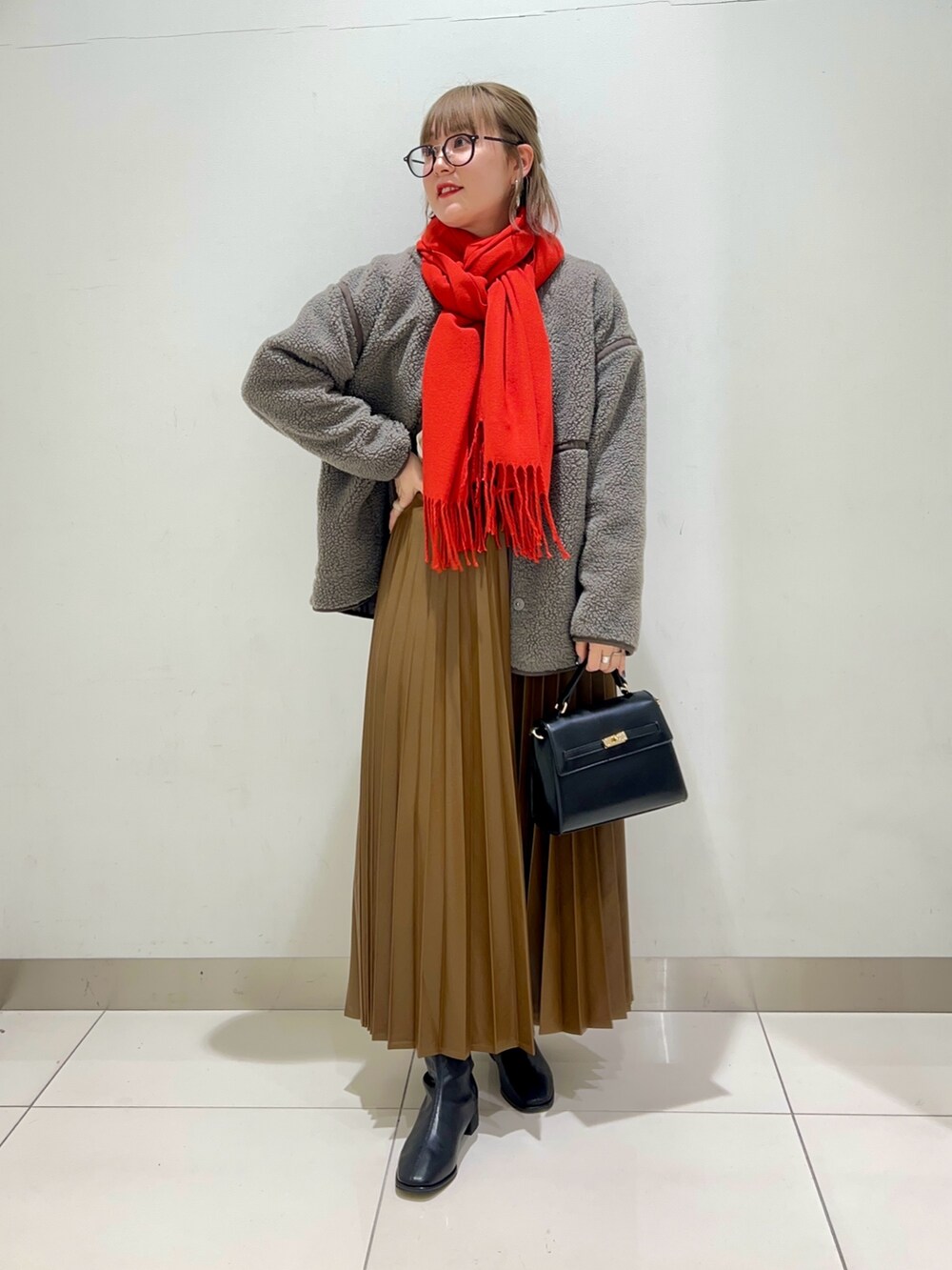 ブラック系のブーツ、ブラウン系のスカート、グレー系のその他アウターを着用したレディースの秋コーディネートの2枚目の写真