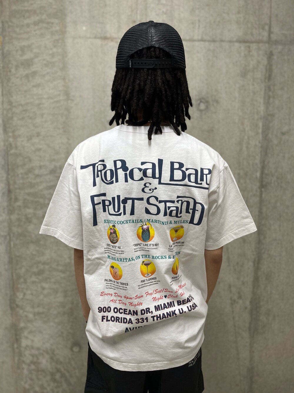 グレー系のカーゴパンツ、ホワイト系のTシャツ/カットソー、ブラック系のキャップを着用したメンズの春コーディネートの4枚目の写真