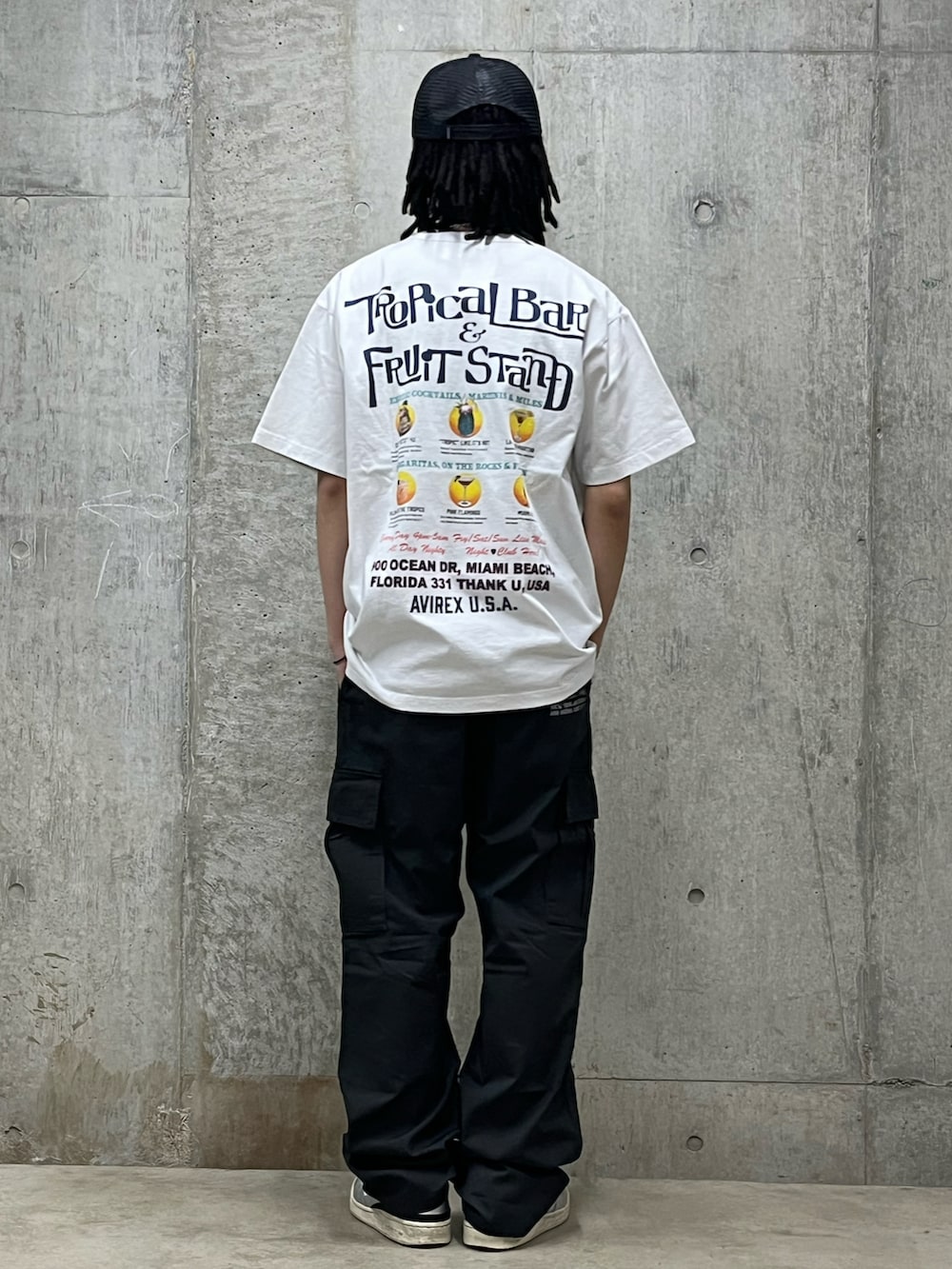 グレー系のカーゴパンツ、ホワイト系のTシャツ/カットソー、ブラック系のキャップを着用したメンズの春コーディネートの2枚目の写真