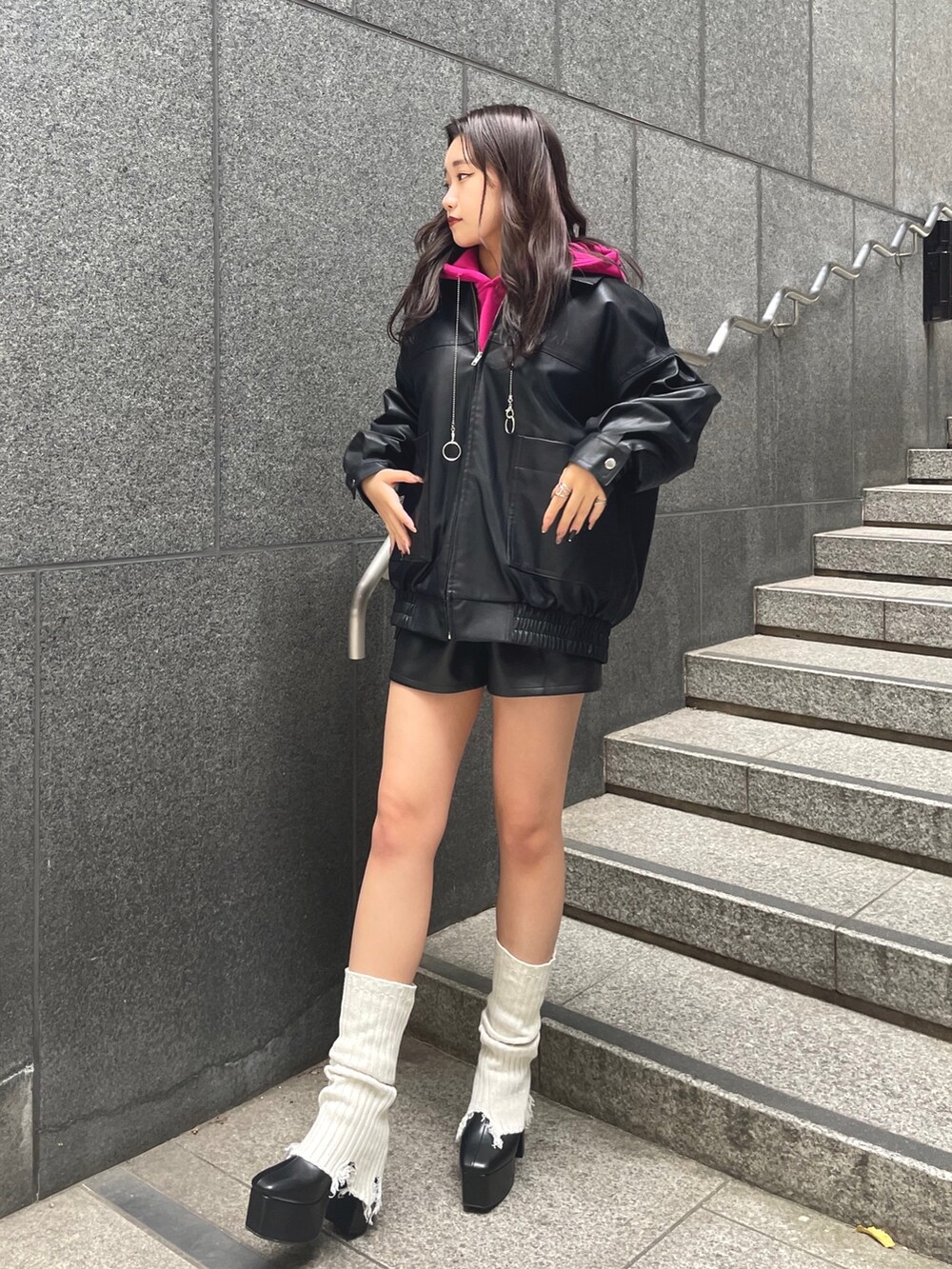 パープル系のパーカー、ブラック系のブルゾン、ブラック系のその他パンツを着用したレディースの秋コーディネートの3枚目の写真