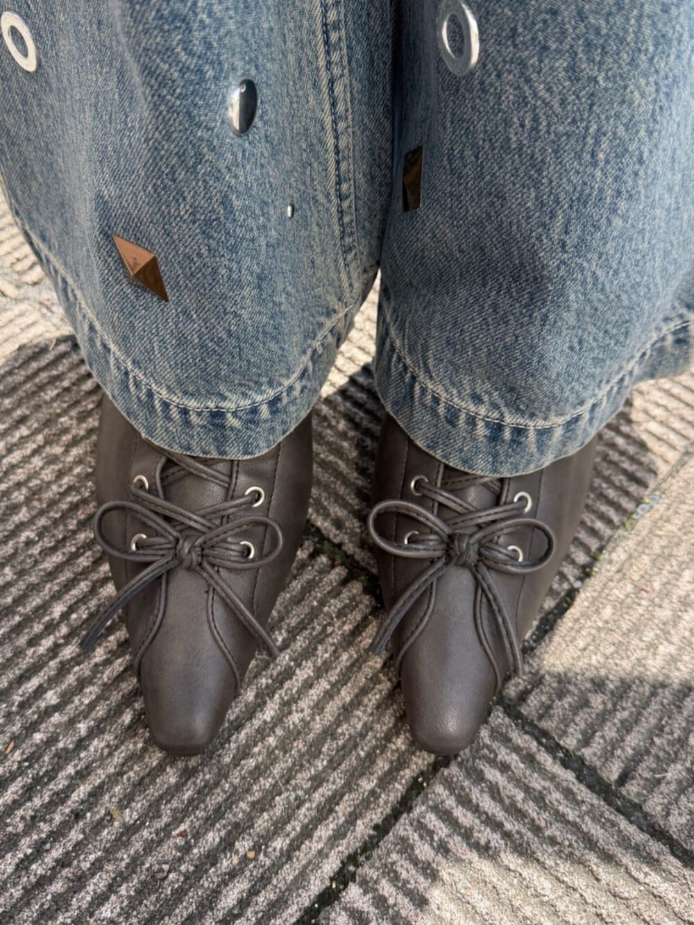 ホワイト系のカーディガン/ボレロ、ブルー系のデニムパンツ、ブラウン系のボストンバッグを着用したレディースの春コーディネートの5枚目の写真