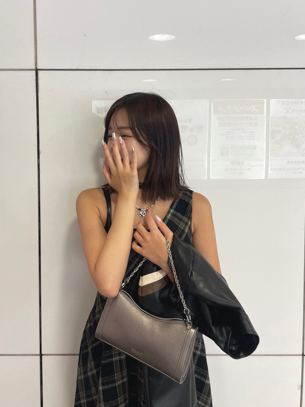 ブラック系のライダースジャケット、シルバー系のショルダーバッグ、ブラック系のワンピースを着用したレディースの秋コーディネートの4枚目の写真