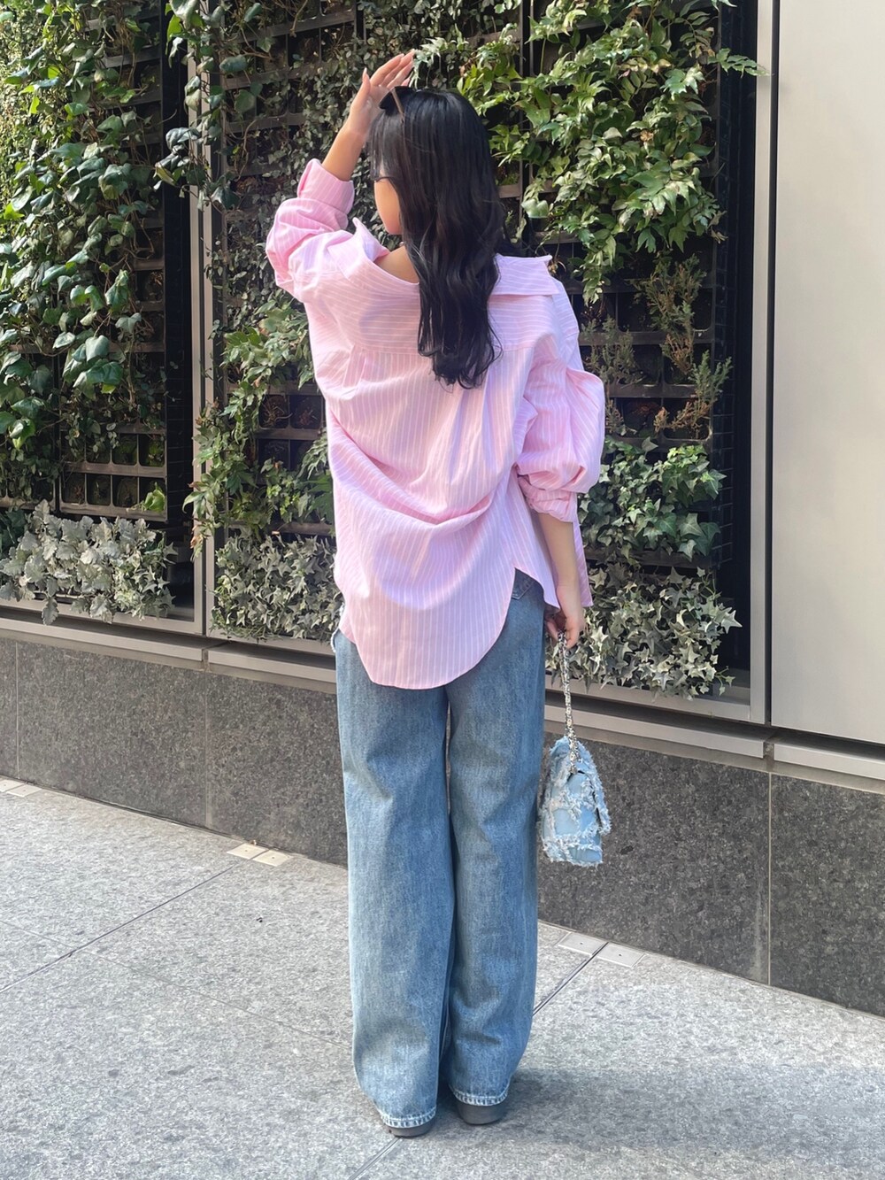 ピンク系のシャツ/ブラウス、ブルー系のデニムパンツ、ブルー系のショルダーバッグを着用したレディースの冬コーディネートの2枚目の写真