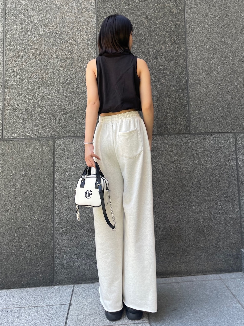 ブラック系のTシャツ/カットソー、ホワイト系のスウェットパンツ、ホワイト系のショルダーバッグを着用したレディースの春コーディネートの3枚目の写真