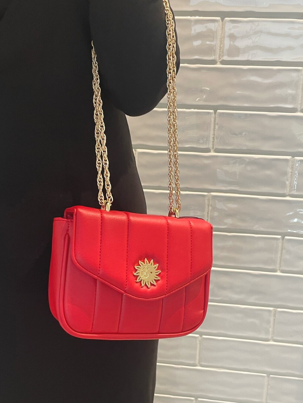 ブラック系のワンピース、ブラック系のブーツ、レッド系のショルダーバッグを着用したレディースの秋コーディネートの5枚目の写真