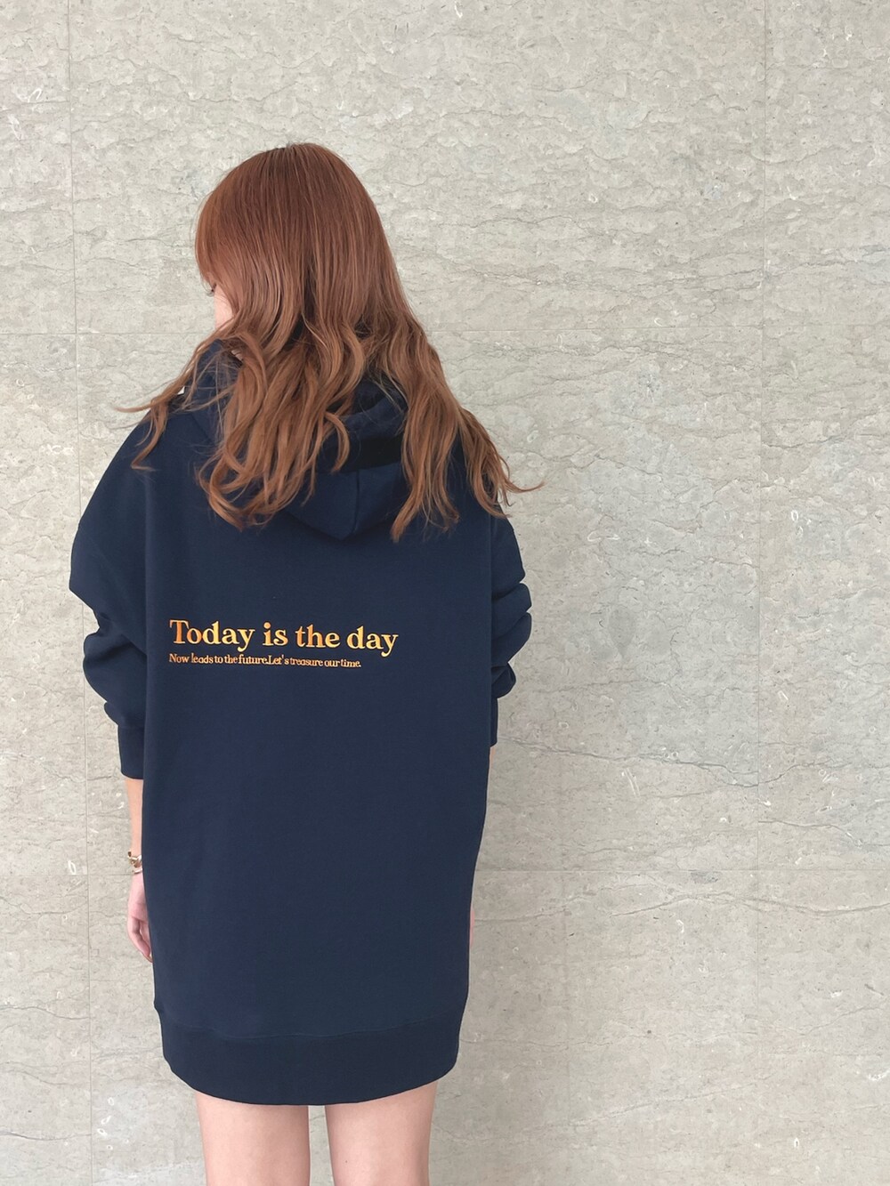 ブルー系のパーカー、ブラック系のブーツ、ゴールド系のバングル/リストバンドを着用したレディースの秋コーディネートの3枚目の写真