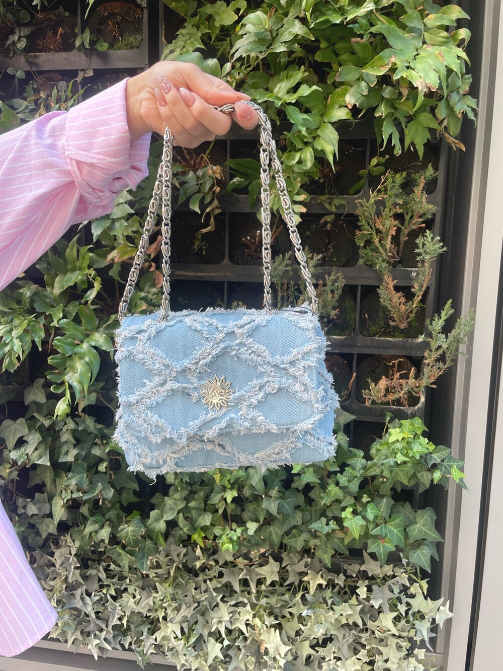 ピンク系のシャツ/ブラウス、ブルー系のデニムパンツ、ブルー系のショルダーバッグを着用したレディースの冬コーディネートの6枚目の写真