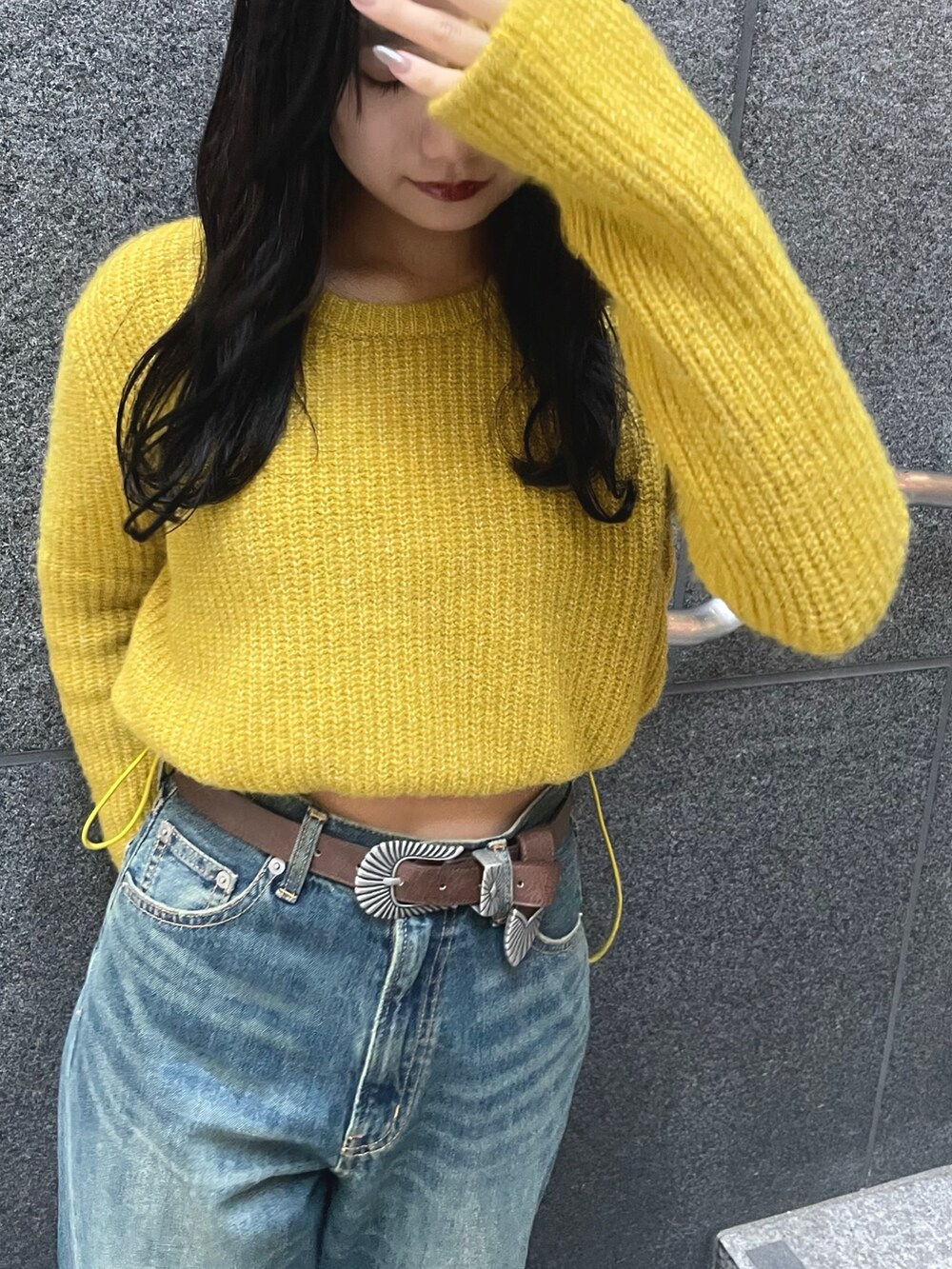 イエロー系のニット/セーター、ブルー系のデニムパンツ、ブラウン系のボストンバッグを着用したレディースの秋コーディネートの3枚目の写真