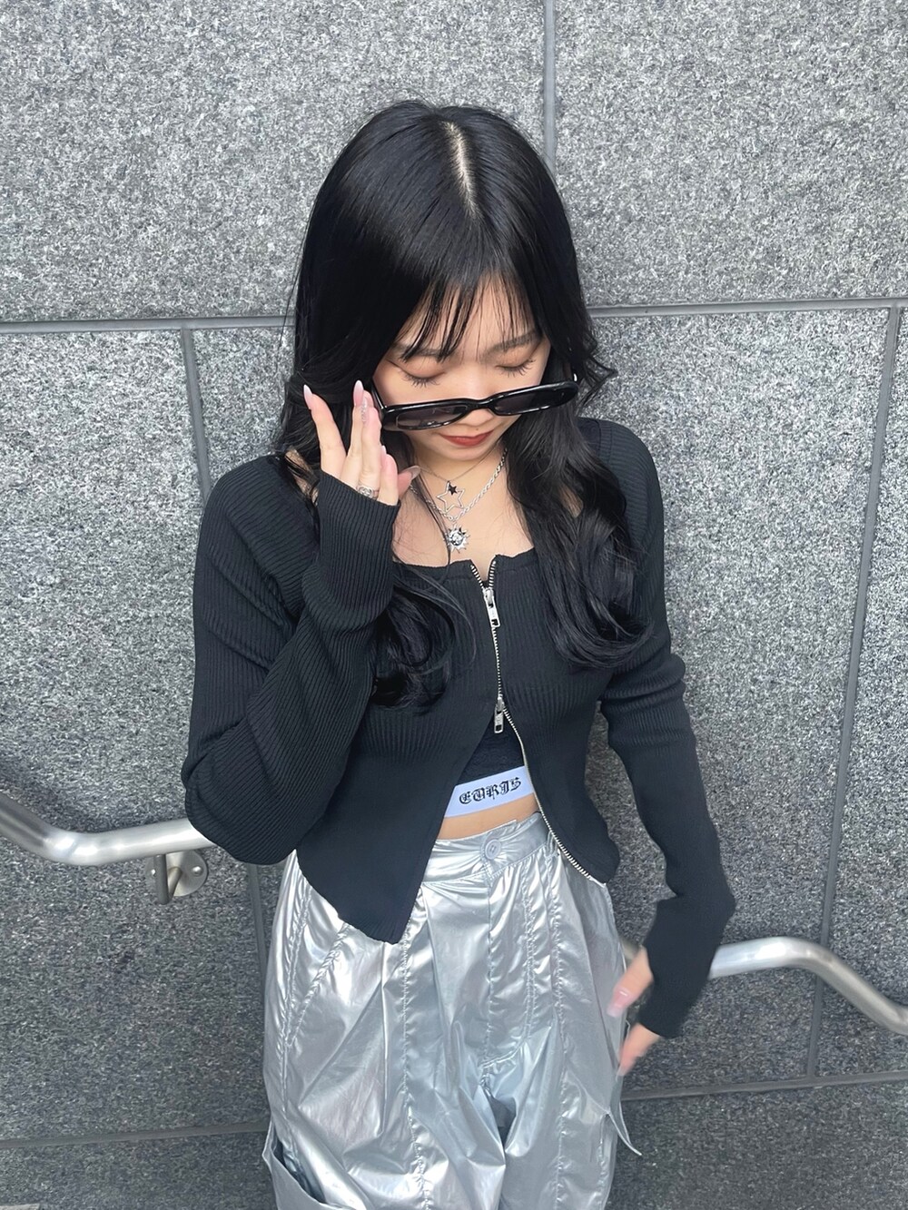 ブラック系のニット/セーター、ブラック系のキャミソール、シルバー系のその他パンツを着用したレディースの春コーディネートの2枚目の写真