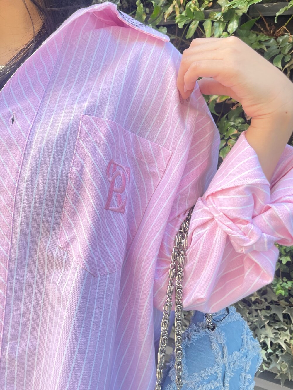 ピンク系のシャツ/ブラウス、ブルー系のデニムパンツ、ブルー系のショルダーバッグを着用したレディースの冬コーディネートの4枚目の写真
