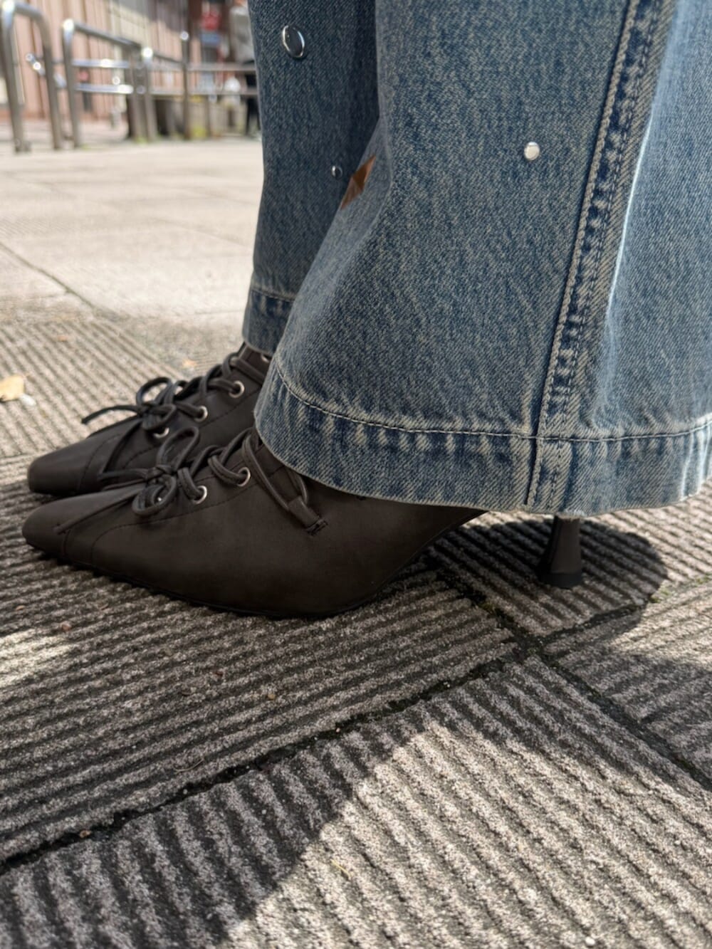 ホワイト系のカーディガン/ボレロ、ブルー系のデニムパンツ、ブラウン系のボストンバッグを着用したレディースの春コーディネートの6枚目の写真