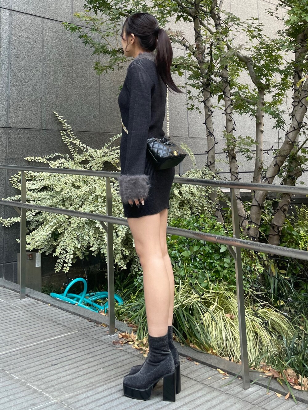 ブラック系のワンピース、ブラック系のショルダーバッグ、その他のブーツを着用したレディースの秋コーディネートの2枚目の写真