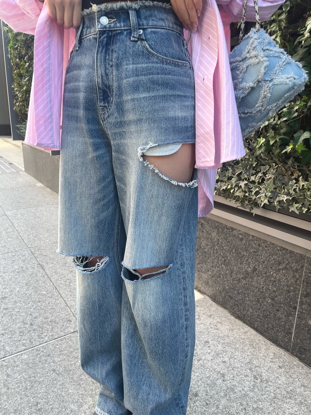 ピンク系のシャツ/ブラウス、ブルー系のデニムパンツ、ブルー系のショルダーバッグを着用したレディースの冬コーディネートの5枚目の写真