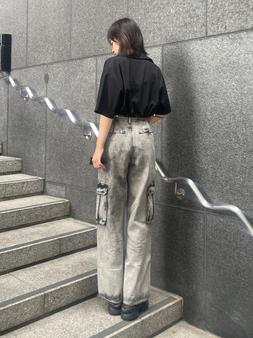 ブラック系のデニムパンツ、ブラック系のサンダル、ブラック系のキャミソールを着用したレディースの夏コーディネートの3枚目の写真