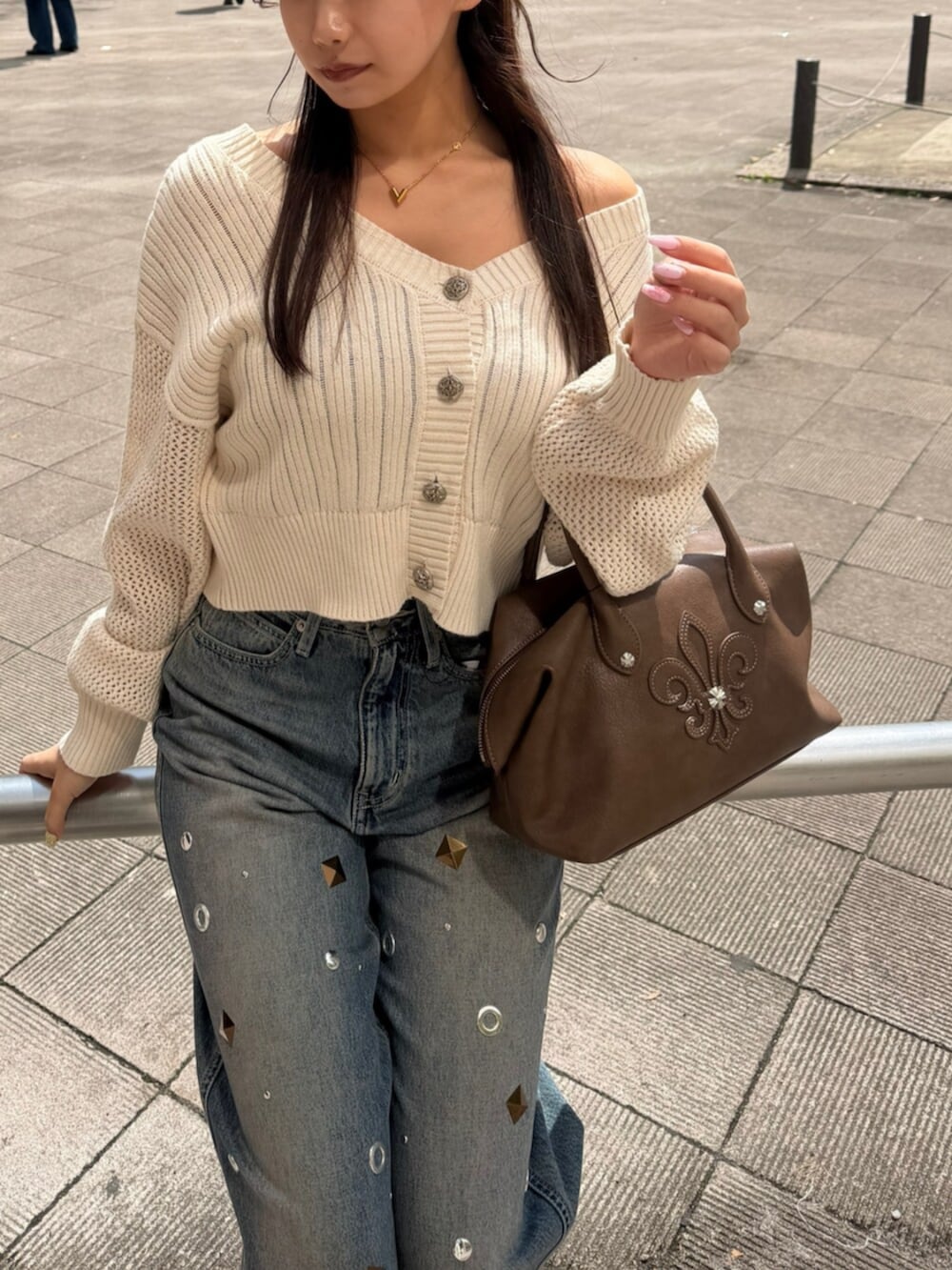 ホワイト系のカーディガン/ボレロ、ブルー系のデニムパンツ、ブラウン系のボストンバッグを着用したレディースの春コーディネートの4枚目の写真