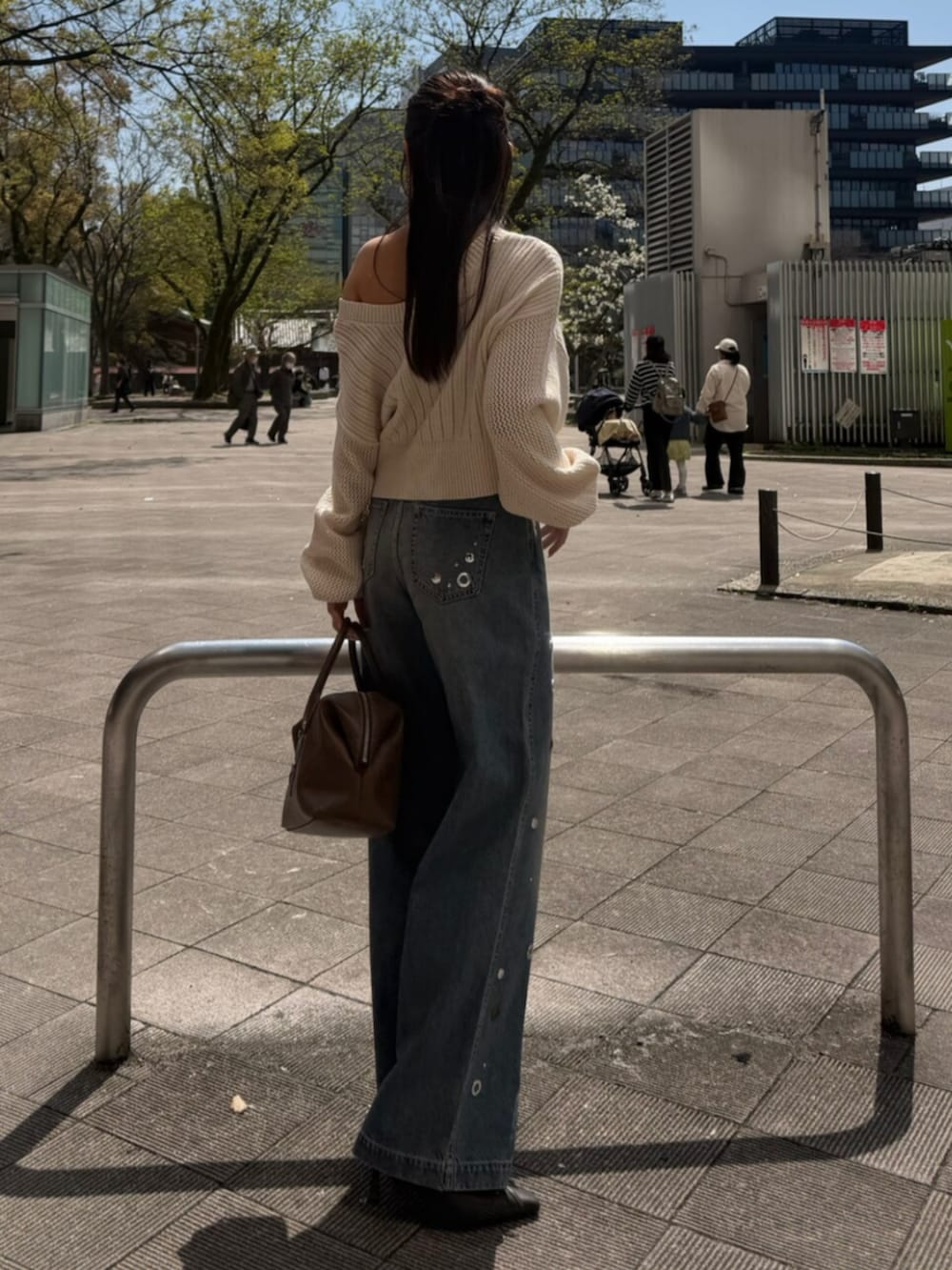 ホワイト系のカーディガン/ボレロ、ブルー系のデニムパンツ、ブラウン系のボストンバッグを着用したレディースの春コーディネートの2枚目の写真