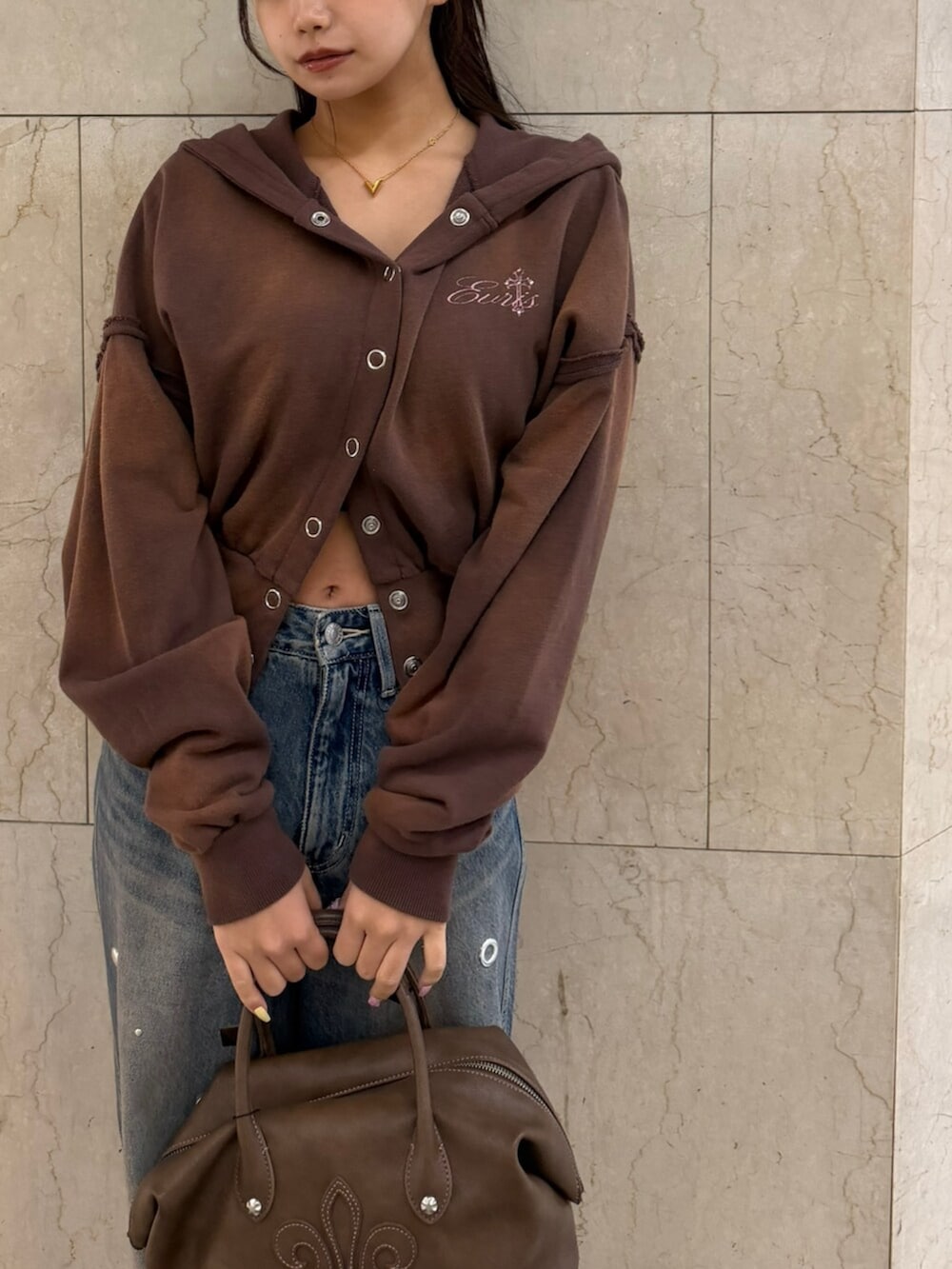 ブラウン系のボストンバッグ、ブラウン系のパーカー、ブラック系のTシャツ/カットソーを着用したレディースの春コーディネートの4枚目の写真