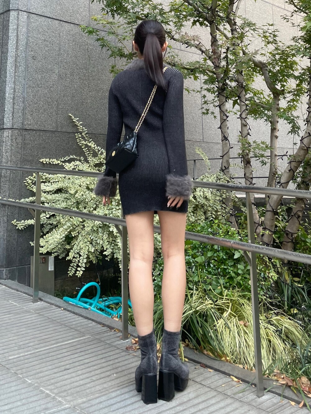 ブラック系のワンピース、ブラック系のショルダーバッグ、その他のブーツを着用したレディースの秋コーディネートの3枚目の写真