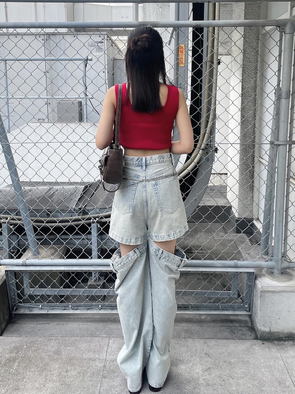 レッド系のTシャツ/カットソー、ブルー系のデニムパンツ、ブラウン系のサンダルを着用したレディースの夏コーディネートの2枚目の写真