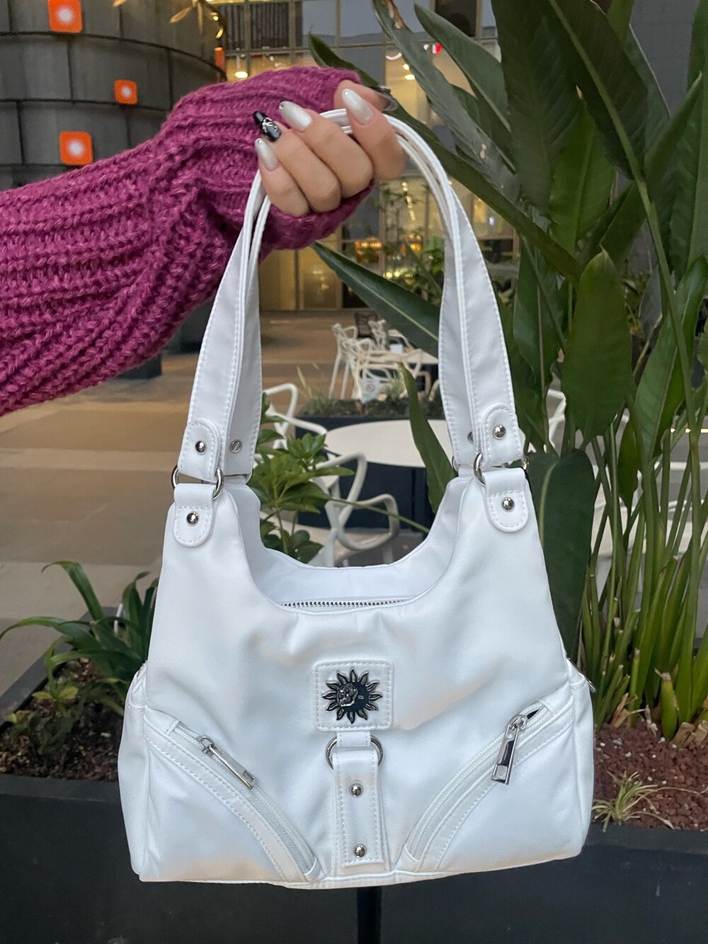 パープル系のニット/セーター、ホワイト系のハンドバッグ、ブルー系のデニムパンツを着用したレディースの冬コーディネートの5枚目の写真