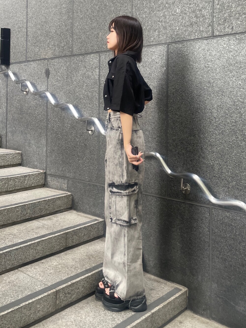 ブラック系のデニムパンツ、ブラック系のサンダル、ブラック系のキャミソールを着用したレディースの夏コーディネートの2枚目の写真