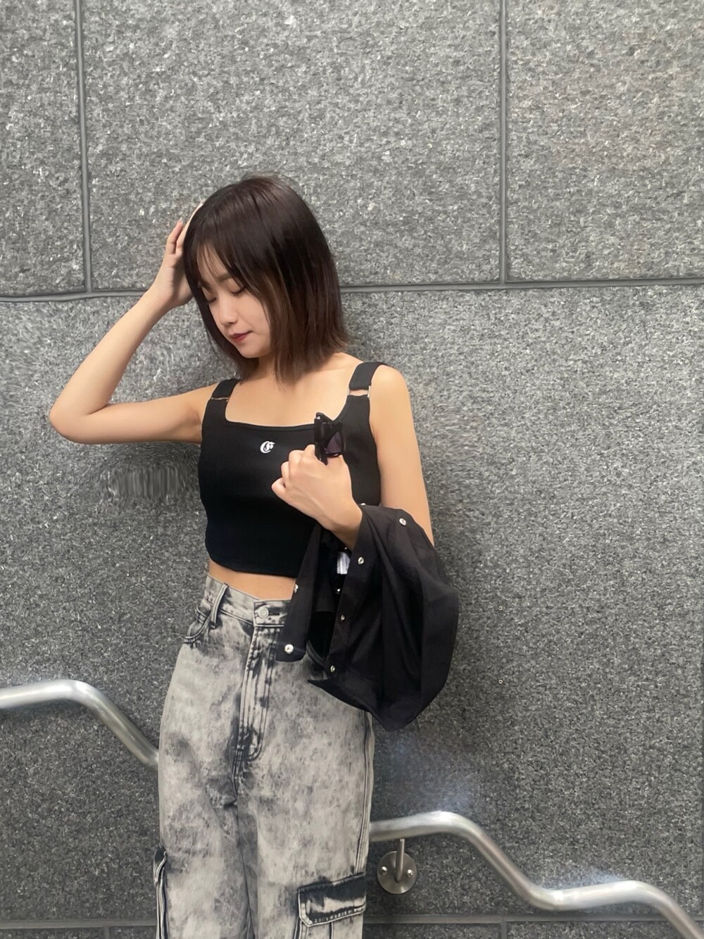 ブラック系のデニムパンツ、ブラック系のサンダル、ブラック系のキャミソールを着用したレディースの夏コーディネートの4枚目の写真