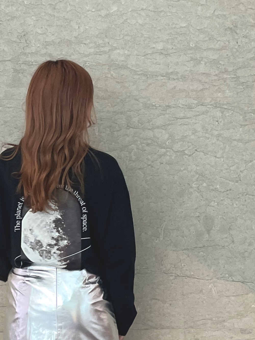 ブラック系のTシャツ/カットソー、シルバー系のスカート、ブラック系のブーツを着用したレディースの秋コーディネートの2枚目の写真