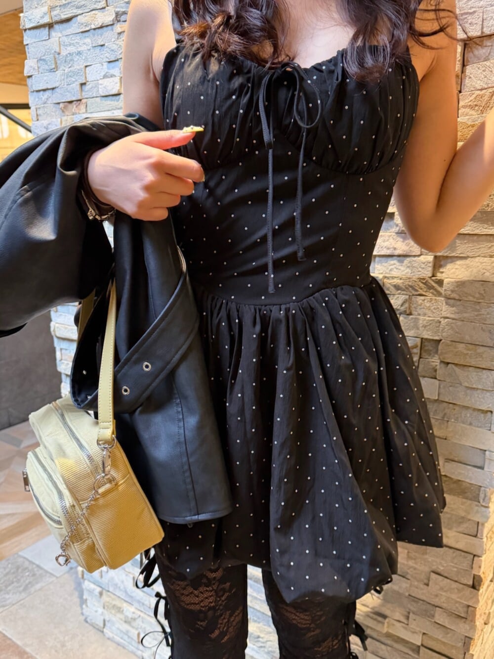 その他のワンピース、イエロー系のハンドバッグ、ブラック系のライダースジャケットを着用したレディースの春コーディネートの4枚目の写真