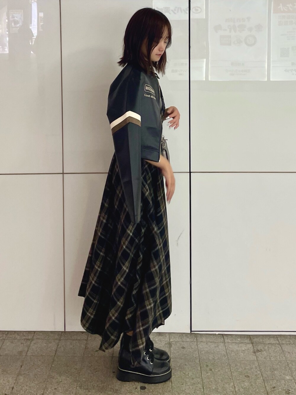 ブラック系のライダースジャケット、シルバー系のショルダーバッグ、ブラック系のワンピースを着用したレディースの秋コーディネートの2枚目の写真