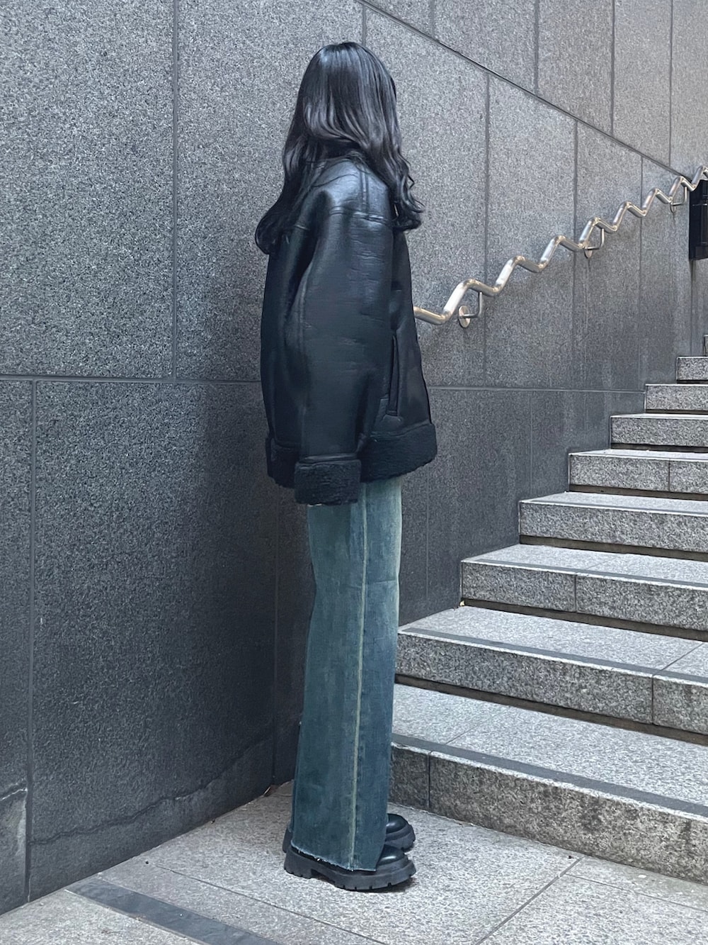 イエロー系のニット/セーター、ブルー系のデニムパンツ、ブラック系のブーツを着用したレディースの秋コーディネートの2枚目の写真