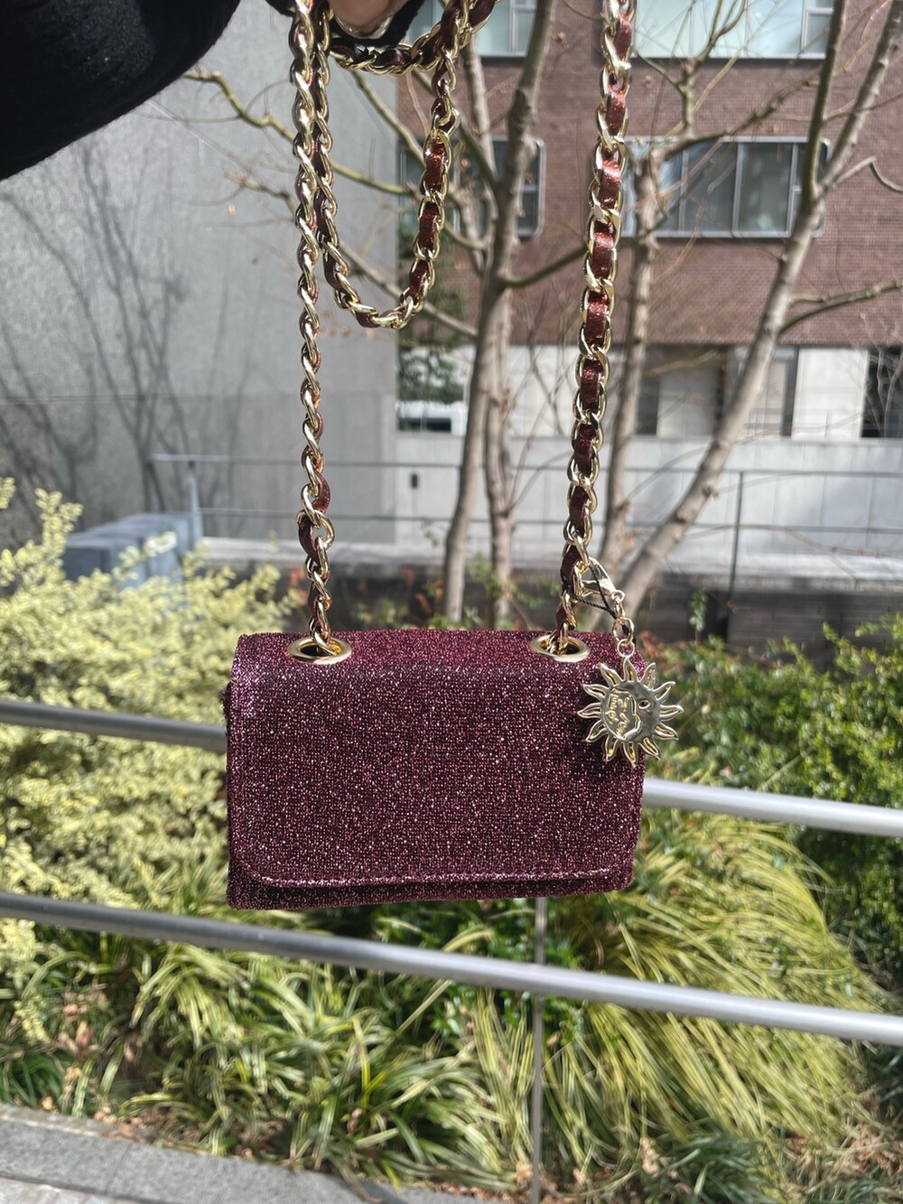 ブラック系のワンピース、ピンク系のショルダーバッグ、ブラック系のブーツを着用したレディースの冬コーディネートの4枚目の写真