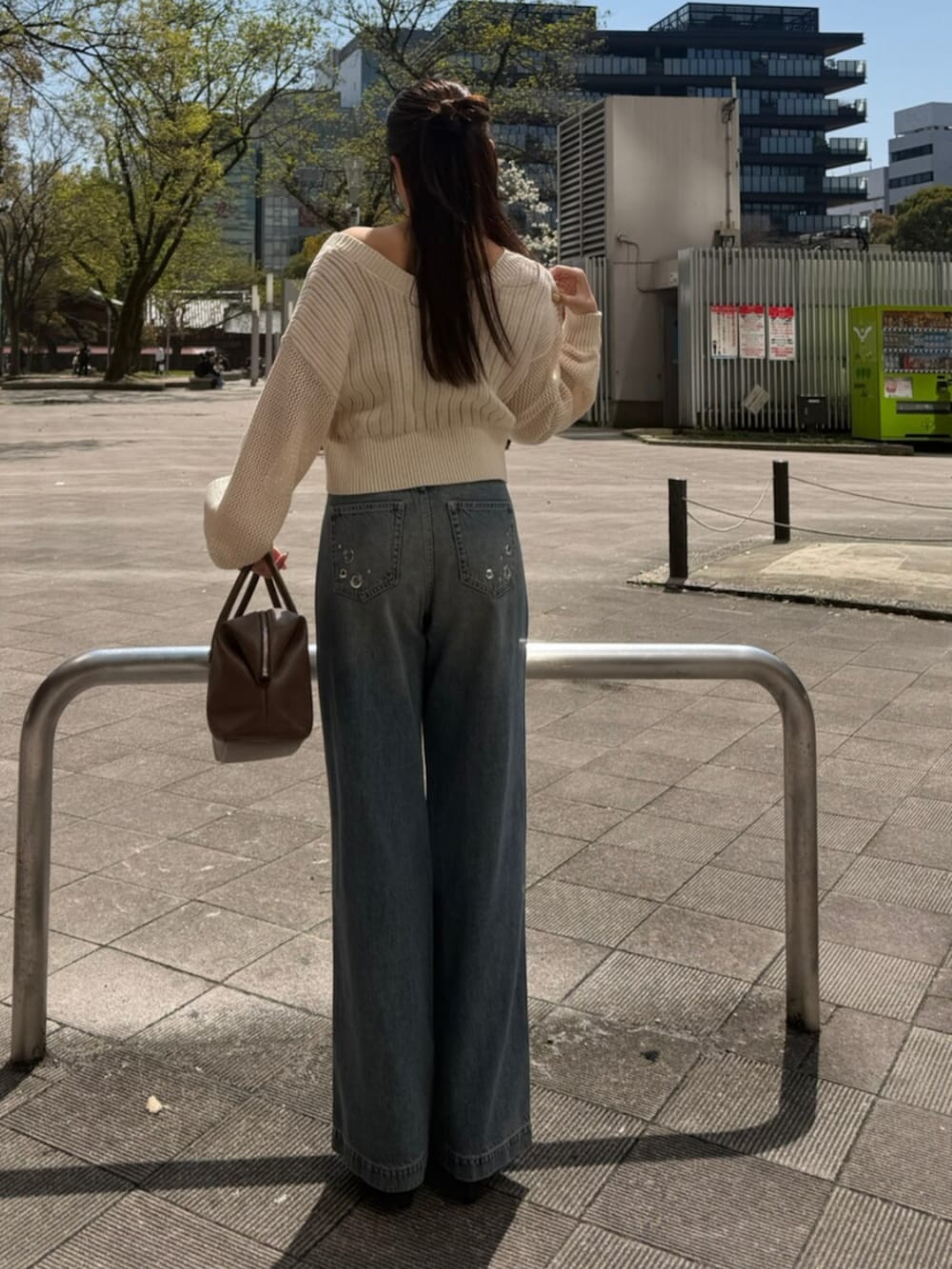 ホワイト系のカーディガン/ボレロ、ブルー系のデニムパンツ、ブラウン系のボストンバッグを着用したレディースの春コーディネートの3枚目の写真