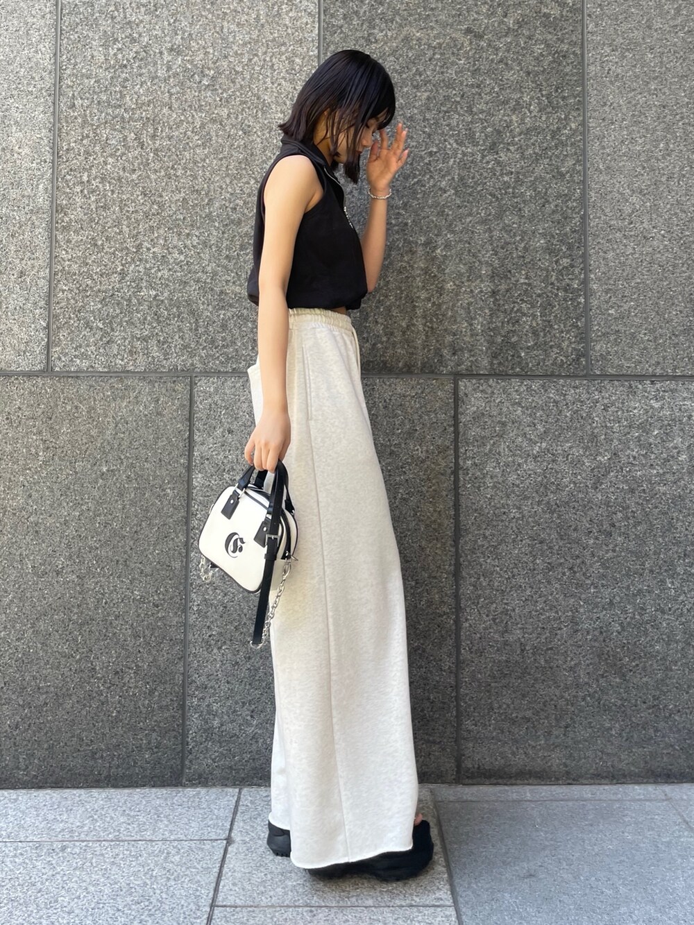 ブラック系のTシャツ/カットソー、ホワイト系のスウェットパンツ、ホワイト系のショルダーバッグを着用したレディースの春コーディネートの2枚目の写真