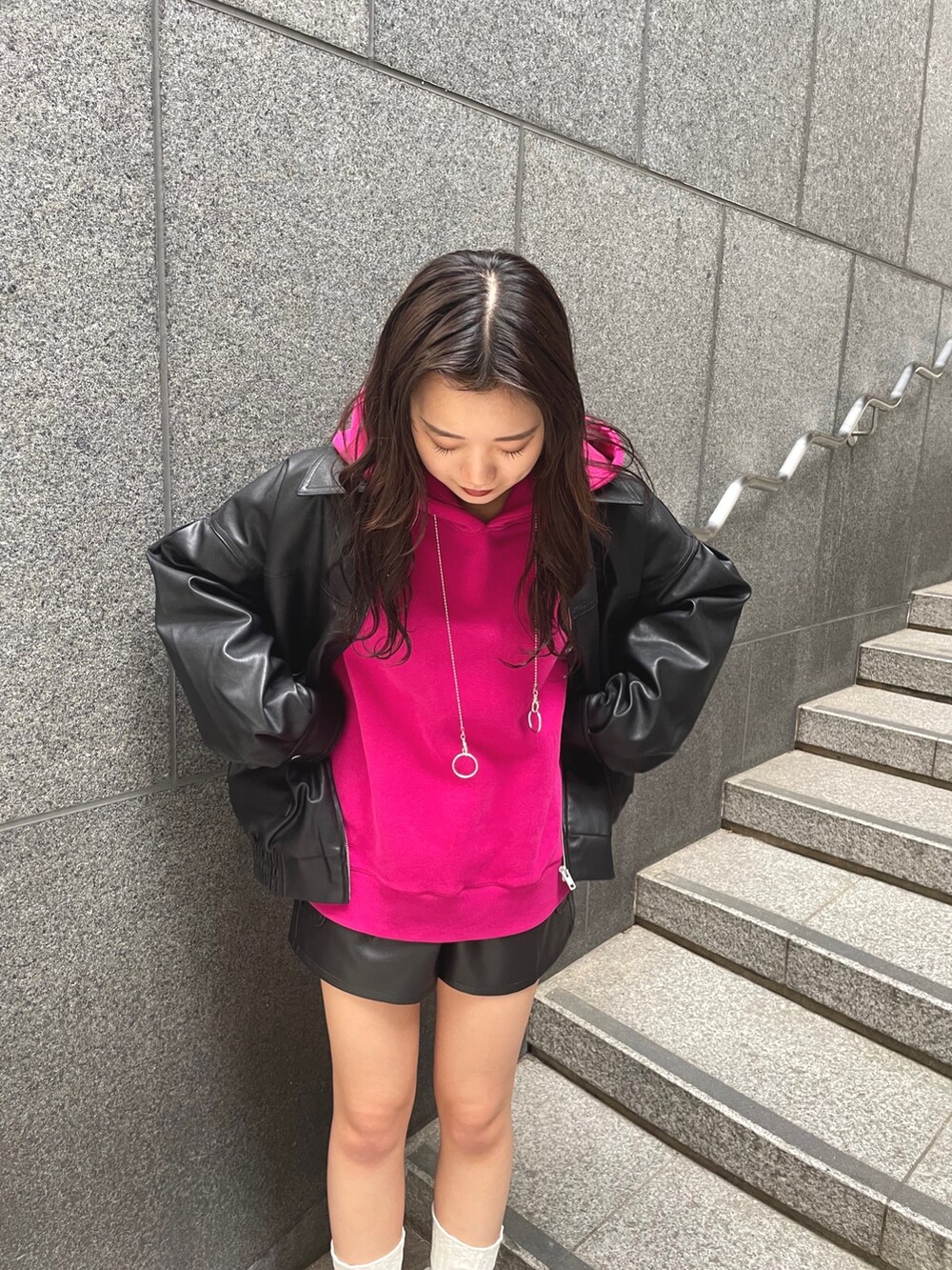 パープル系のパーカー、ブラック系のブルゾン、ブラック系のその他パンツを着用したレディースの秋コーディネートの4枚目の写真