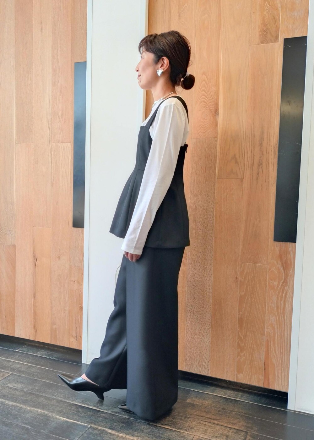 ホワイト系のハンドバッグを着用したレディースの冬コーディネートの2枚目の写真