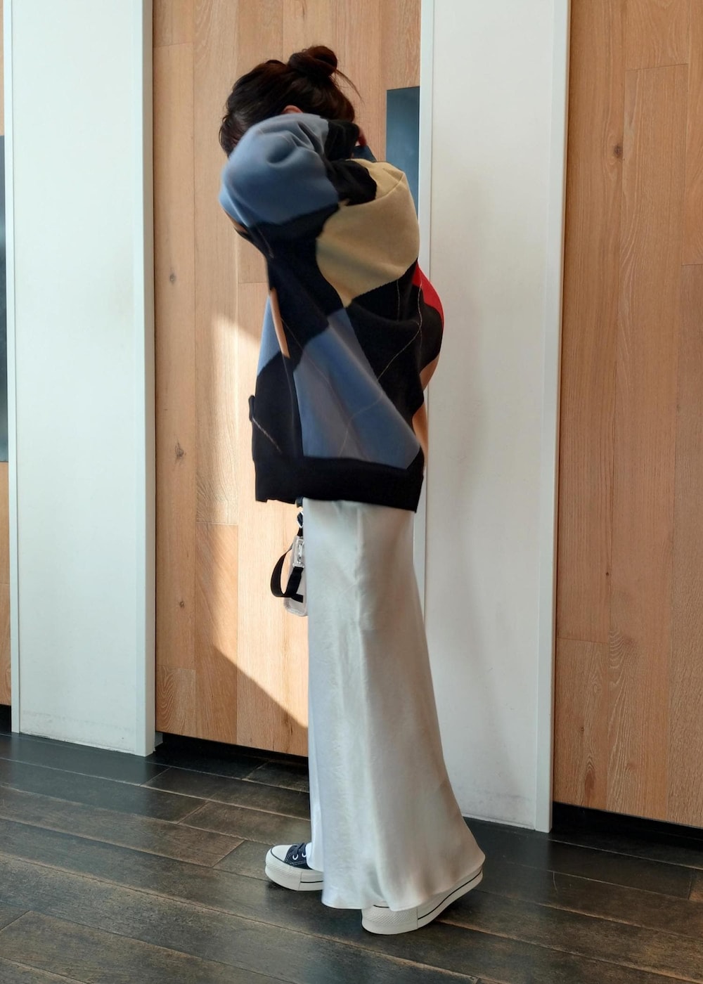 ベージュ系のトートバッグ、ブラック系のカーディガン/ボレロ、ホワイト系のスカートを着用したレディースの冬コーディネートの3枚目の写真