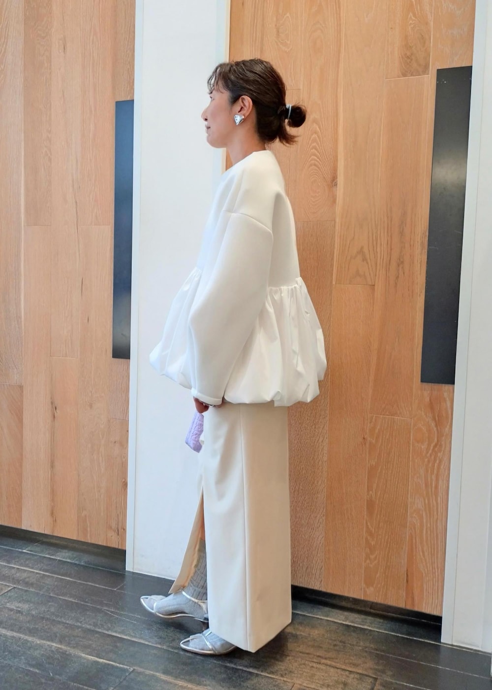 シルバー系のサンダル、ホワイト系のカーディガン/ボレロ、ホワイト系のスカートを着用したレディースの冬コーディネートの2枚目の写真