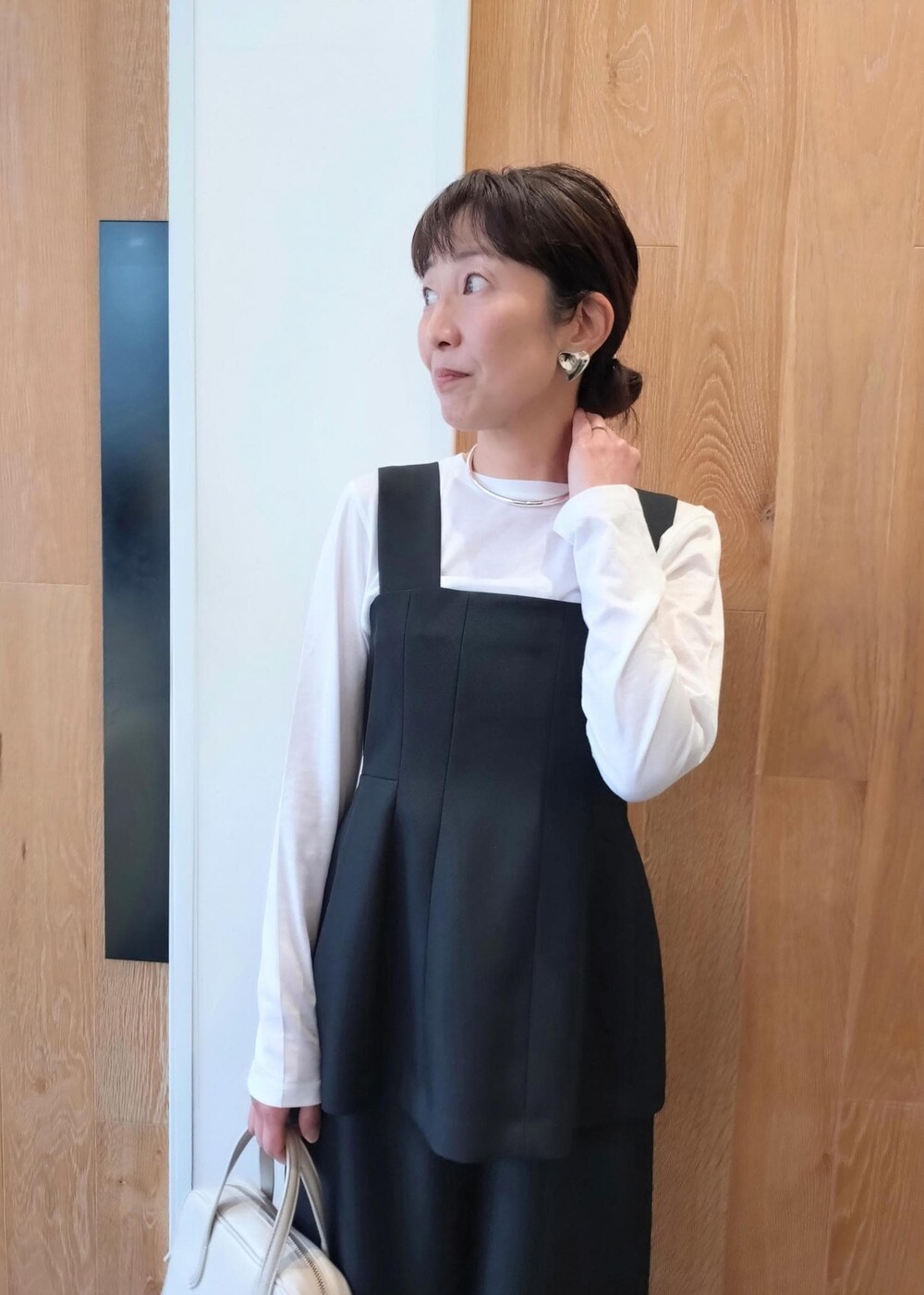 ホワイト系のハンドバッグを着用したレディースの冬コーディネートの4枚目の写真