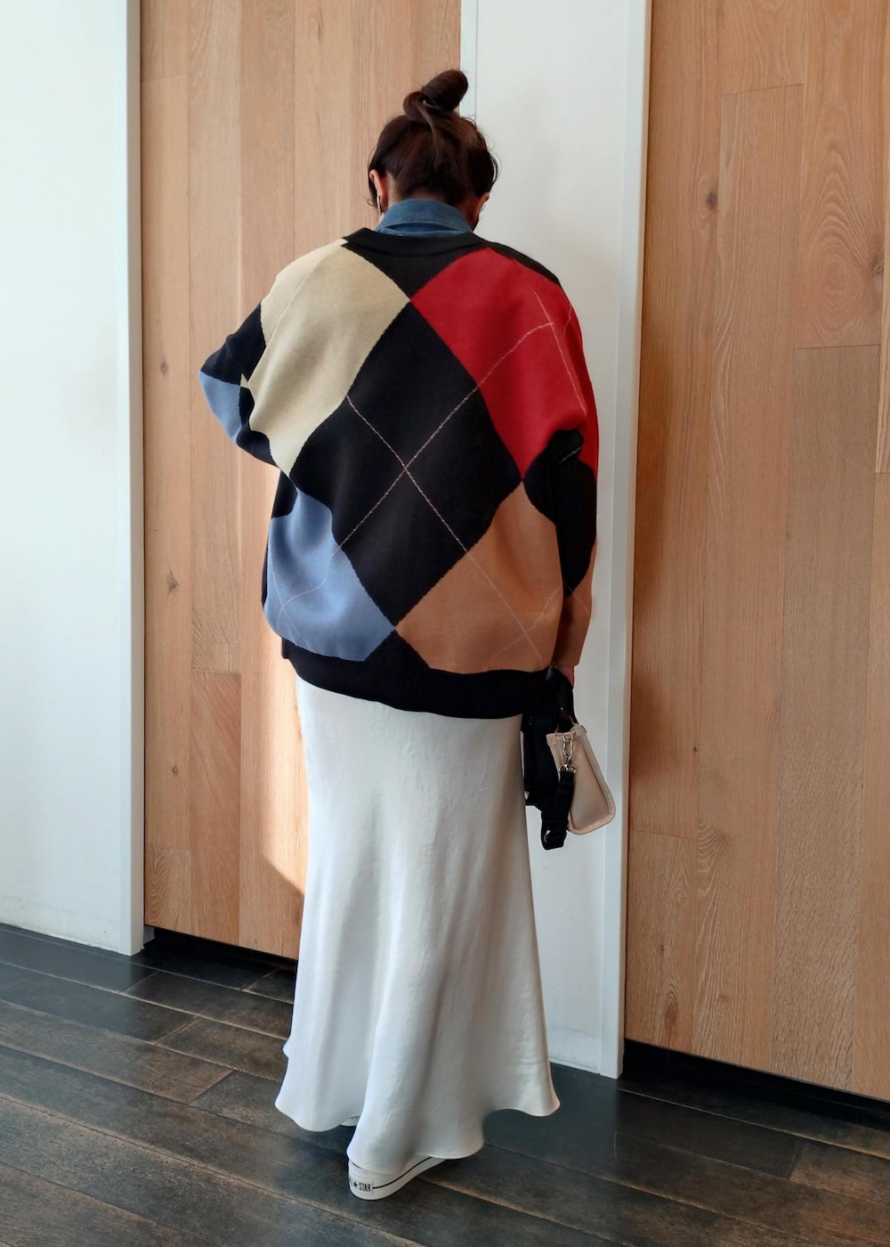 ベージュ系のトートバッグ、ブラック系のカーディガン/ボレロ、ホワイト系のスカートを着用したレディースの冬コーディネートの4枚目の写真