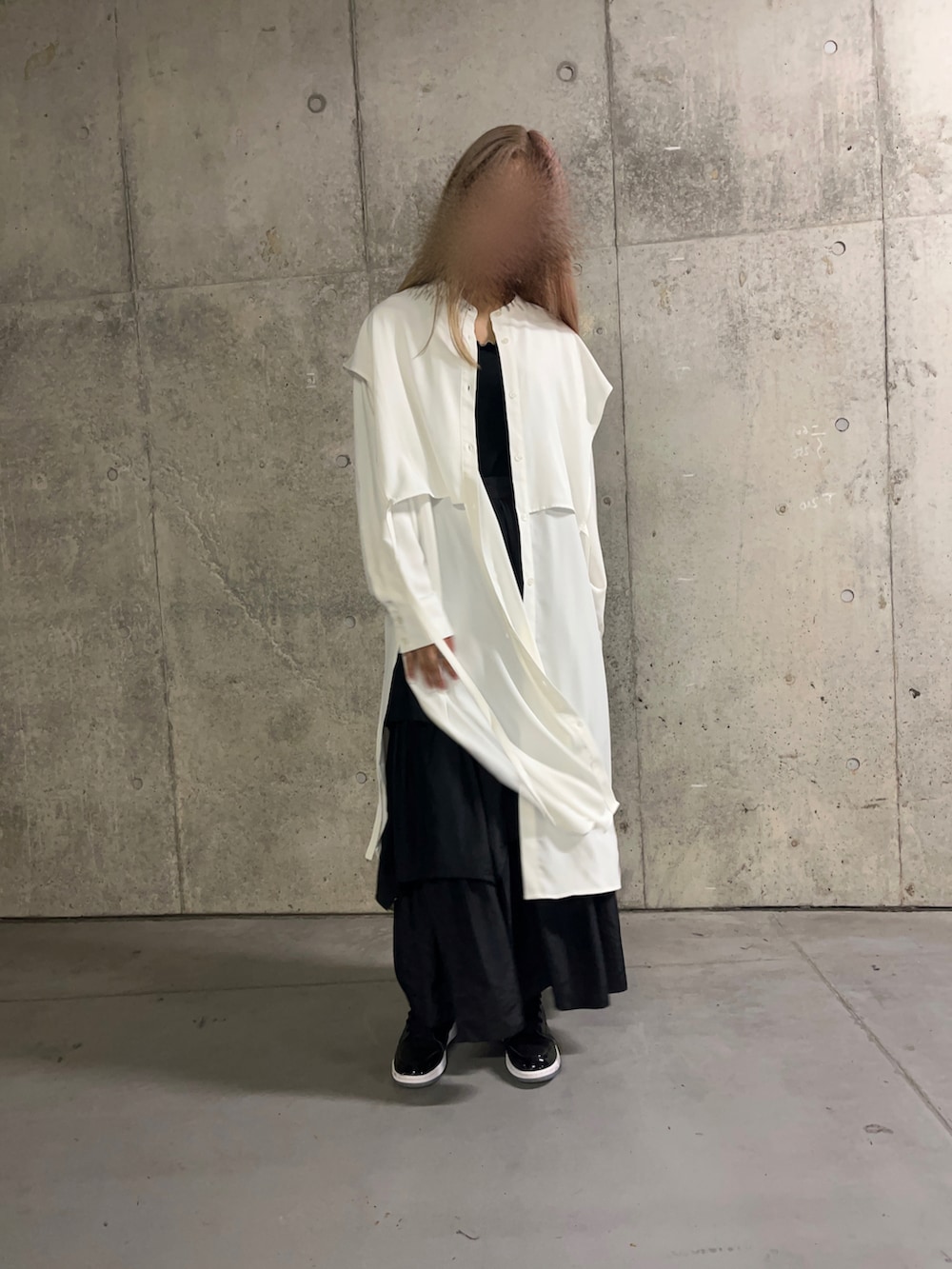 ブラック系のスカート、ブラック系のスニーカー、ホワイト系のシャツ/ブラウスを着用したレディースの秋コーディネートの2枚目の写真