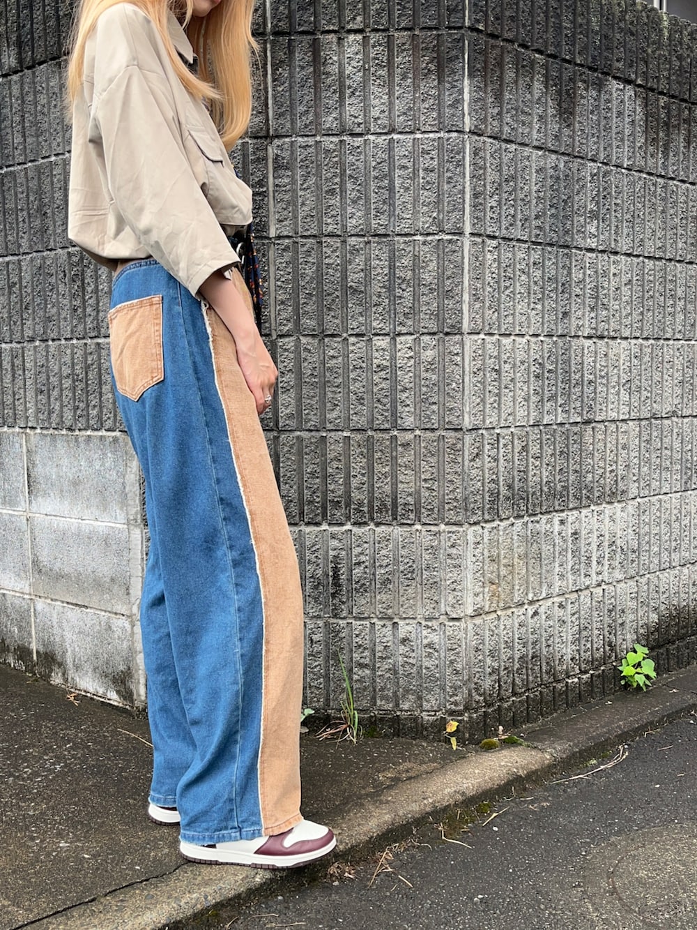 ブルー系のデニムパンツ、ブラウン系のスニーカー、ブルー系のネクタイを着用したレディースの夏コーディネートの2枚目の写真
