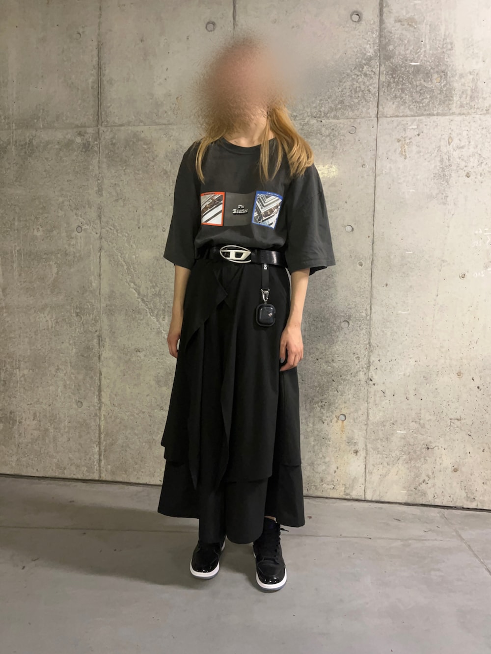 ブラック系のスカート、ブラック系のスニーカー、グレー系のTシャツ/カットソーを着用したレディースの夏コーディネートの2枚目の写真