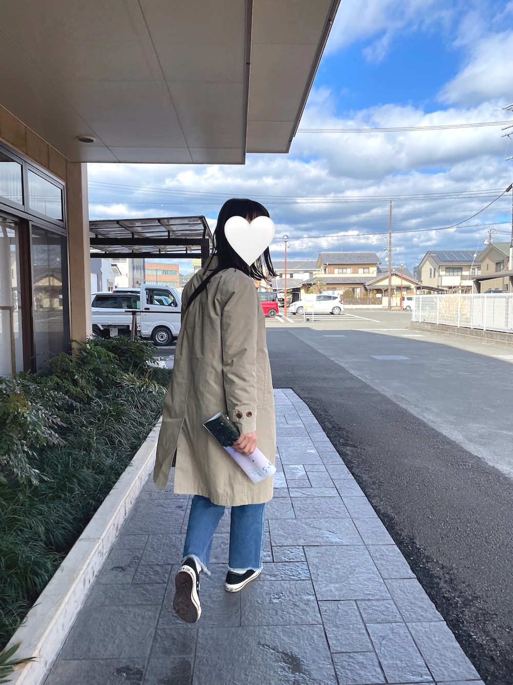 ベージュ系のトレンチコート、ブルー系のデニムパンツを着用したレディースの冬コーディネートの2枚目の写真